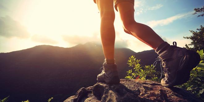 A hiker walking into beautiful sun