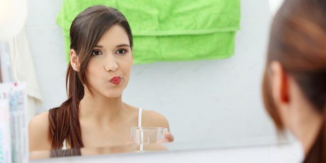 a woman rinsing her mouth with oil