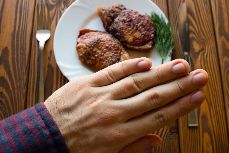 a man refusing a delicious steak