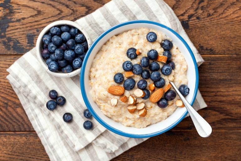 a bowl of coconut porridge with almonds and blueberries