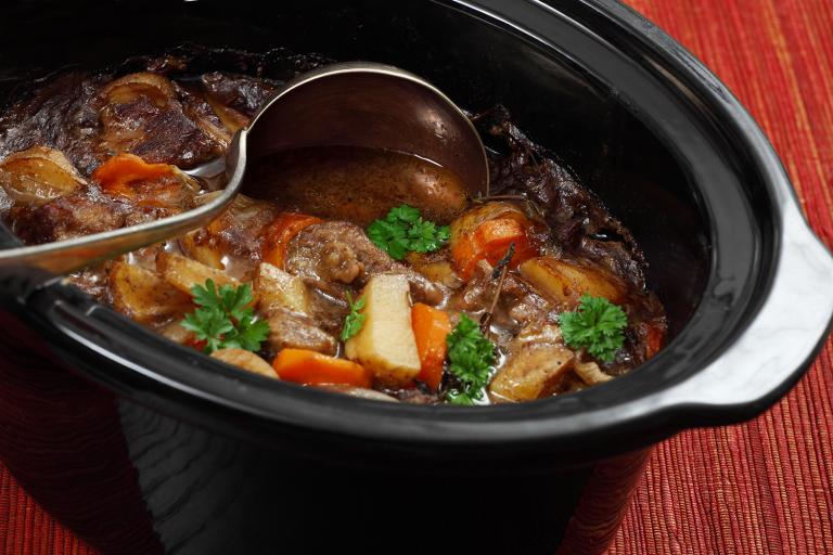 A pot full of hearty beef stew with carrots and potatoes.