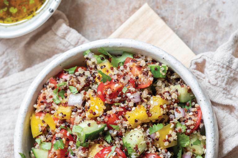 Top view of Quinoa Tabbouleh in a white bowl on flour sack cloth.